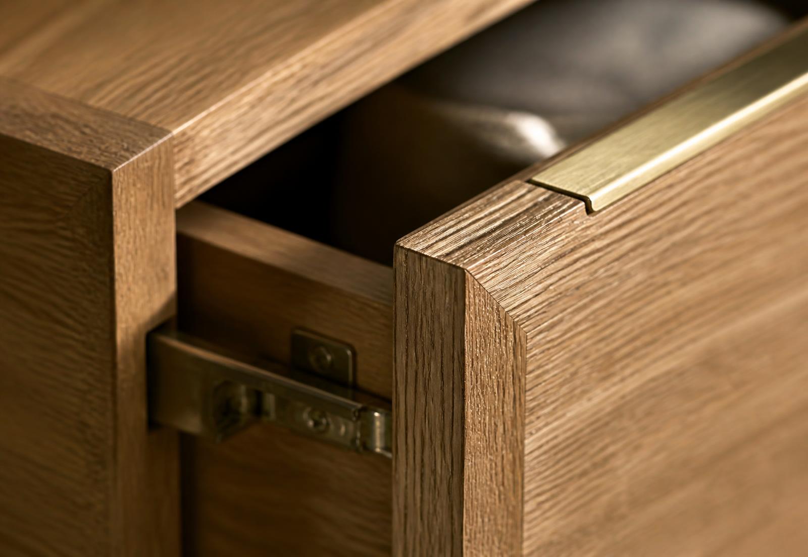Close-up of oak drawer joinery, soft-close hardware and a brass edge detail
